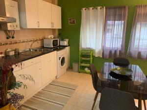 a kitchen with a table and a dining room at Charming T1 apartment in Seixal in Aldeia de Paio Pires