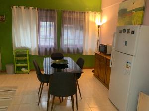 a kitchen with a table and a white refrigerator at Charming T1 apartment in Seixal in Aldeia de Paio Pires