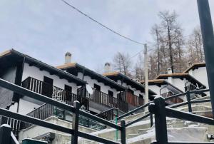 a building with snow on the ground in front of it at Valtournenche EVETTE in Valtournenche