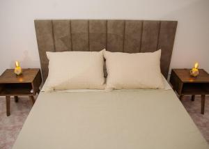 a large bed with two night stands and two tables at Depto 5 in Villa Carlos Paz
