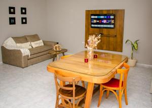 a living room with a wooden table and chairs at Depto 5 in Villa Carlos Paz +4 photos
