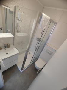 a white bathroom with a shower and a toilet at Jelsa Blue Sea View in Jelsa +39 photos