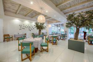 uma sala de jantar com mesas, cadeiras e árvores em Grand Sirenis Punta Cana Resort & Aquagames - All Inclusive em Punta Cana
