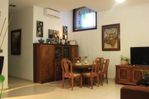 comedor con mesa, sillas y TV en Casa Rural la Plaza, en Almoharín