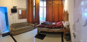um quarto com uma cama, um sofá e uma janela em Three Star Hotel & Restaurent Malam jabba swat em Malam Jabba
