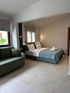 a bedroom with a bed and a couch in a room at Zinozis Beach Apartments in Vourvourou