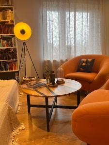 uma sala de estar com uma mesa de centro e 2 cadeiras em Apartament Leszczyna em Olsztyn