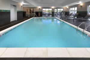 a large swimming pool in a hotel with blue lighting at TownePlace Suites by Marriott St. Louis Edwardsville, IL in Edwardsville