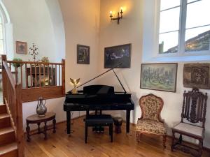 ein Wohnzimmer mit einem Klavier und einem Stuhl in der Unterkunft Chapel Retreat near Glastonbury in Bridgwater