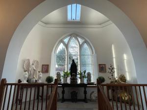 einen Torbogen in einer Kirche mit Statuen auf dem Tisch in der Unterkunft Chapel Retreat near Glastonbury in Bridgwater