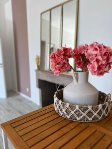 a vase filled with pink flowers sitting on a table at Détente et vue exceptionnelle à L'appart' de Charles in Dole