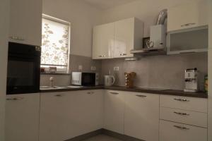a kitchen with white cabinets and a window at Apartman Stella in Pula