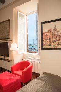 - une chambre avec une chaise rouge et une fenêtre dans l'établissement B&B Peruzzi Rooms, à Civitavecchia
