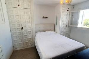 1 dormitorio pequeño con 2 puertas blancas y 1 cama en Villa Oasis 10 pers, piscina, BBQ, 10 min playa, en El Tosalet