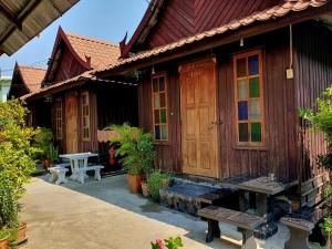 a wooden house with a bench in front of it at KTT Resort Sukhothai & Motorbikes for rent & bicycles for rent in Sukhothai