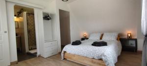 1 dormitorio con 1 cama con 2 toallas negras en Gîte 1 Des Abbayes Du Val De Seine, 