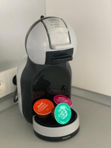 Una cafetera con cuatro botones de colores diferentes. en Détente et vue exceptionnelle à L'appart' de Charles en Dole