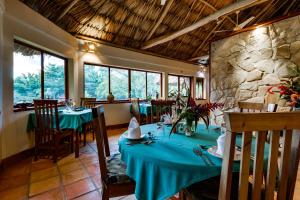 a dining room with a table and a stone wall at Tanager RainForest Lodge in Big Falls