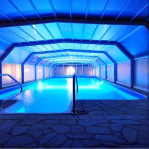 una piscina con luci blu sul soffitto di Sunny Hill Apartments & Aqua Park a Vrnjačka Banja