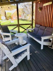 2 Liegestühle und ein Tisch auf der Terrasse in der Unterkunft Övraby Stuga in Gödeby