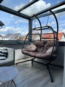 ジンスハイムにあるLifeStyle Apartment Sinsheimの窓付きの客室内のスイングチェア