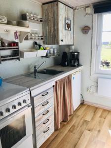 a kitchen with a sink and a stove top oven at Övraby Stuga in Gödeby