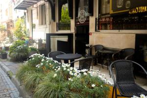 un patio con sillas, mesas y flores frente a un restaurante en Pearl Hotel İstanbul, en Estambul