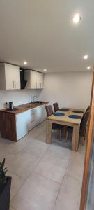 a kitchen with a wooden table and a table and chairs at Apartament Kopernik in Bystrzyca Kłodzka