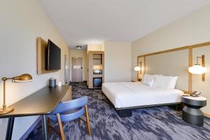 a hotel room with a bed and a desk at Fairfield Inn & Suites Bardstown in Bardstown