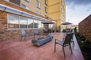 eine Terrasse mit Stühlen und einer Feuerstelle vor einem Gebäude in der Unterkunft Fairfield Inn & Suites Bardstown in Bardstown