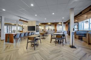 a restaurant with tables and chairs and a bar at Fairfield Inn & Suites Bardstown in Bardstown