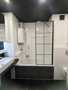 a bathroom with a shower and a tub and a sink at Przytulne mieszkanko in Oświęcim +18 photos