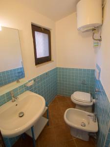 a bathroom with a sink and a toilet and a mirror at Appartamento Santa Maria Porto Pollo in Palau