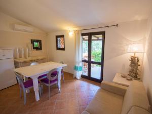 a kitchen and dining room with a table and a couch at Appartamento Santa Maria Porto Pollo in Palau