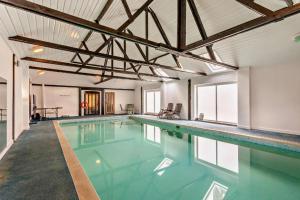 a large swimming pool with blue water in a building at PondView Cottage with swimming pool, and garden in Tibenham