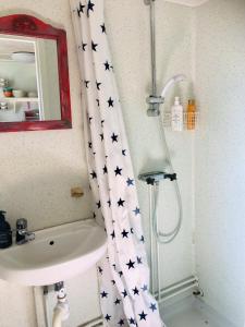 a bathroom with a sink and a shower curtain with stars at Övraby Stuga in Gödeby