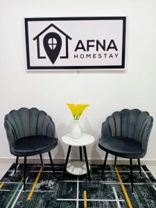 due sedie e un tavolo davanti a un cartello di Afna Home stay a Kuala Lipis