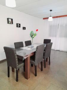 a dining room table with chairs and a vase of flowers on it at "Village" Amplia CASA boutique con parrilla y 2 garages in Corrientes