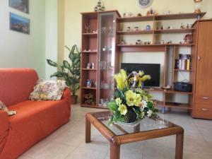 een woonkamer met een bank en een tafel met bloemen erop bij Villa Selene "Jole" in Ioppolo