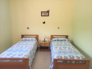 een slaapkamer met 2 bedden en een tafel met een lamp bij Villa Selene "Jole" in Ioppolo