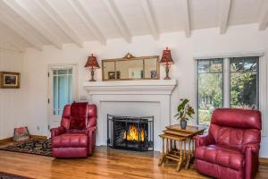 a living room with two chairs and a fireplace at 3757 Garden House Sanctuary home in Carmel
