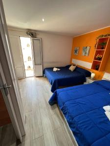 two beds in a room with blue sheets at Verde Mare in Trapani