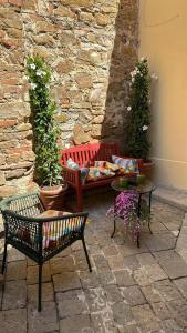 a patio with benches and tables and a stone wall at San Giorgino Home in Florence