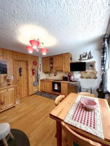 a kitchen with wooden cabinets and a wooden table at Casetta dei Cuori - Alpine Style Cozy Apartment in Folgarida