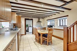 a kitchen with a table and chairs in a room at PondView Cottage with swimming pool, and garden in Tibenham