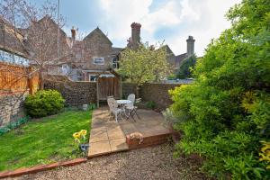 a garden with a table and chairs on a wooden deck at Albert's Rest in Ramsgate