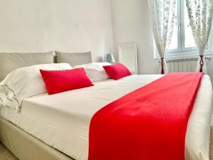 Una gran cama blanca con almohadas rojas. en Families or Groups 3 Terrazzi Apartment on Sea, en Vernazza