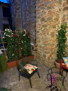 a patio with flowers and a chair and a brick wall at San Giorgino Home in Florence