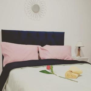 a bed with pink and black sheets and pillows at "Village" Amplia CASA boutique con parrilla y 2 garages in Corrientes