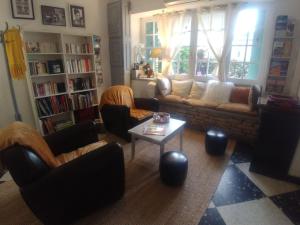 L'Aiguebelle في Céreste: غرفة معيشة مع أريكة وكراسي وطاولة